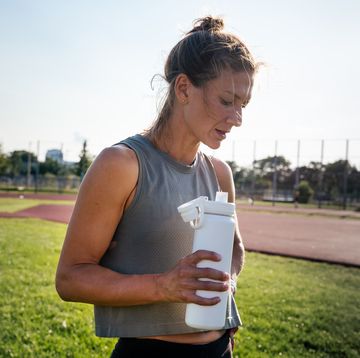 dehydration symptoms runner holds a water bottle after a track workout