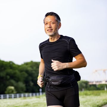 Active Japanese senior man jogging against the sunshine active japanese senior man jogging against the sunshine