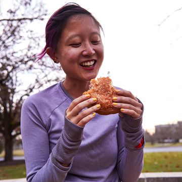 woman wearing running clothes holds an impossible whopper