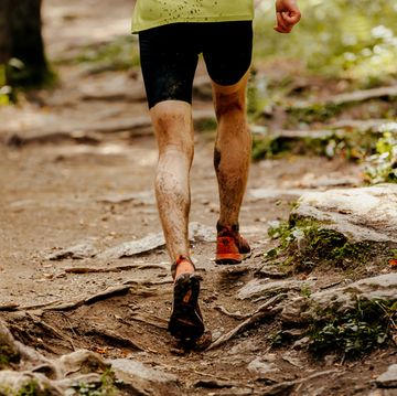 athlete runner dirty feet running forest trail cross country training