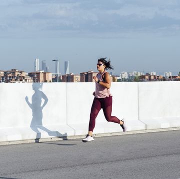 Athletic woman running in the street, running base, base training running plan athletic woman running in the street, running base, base training running plan
