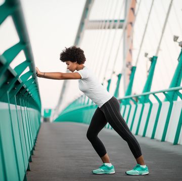 athletic, young woman exercising on city bridge