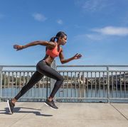 Attractive ethnic female sprinter training in the city