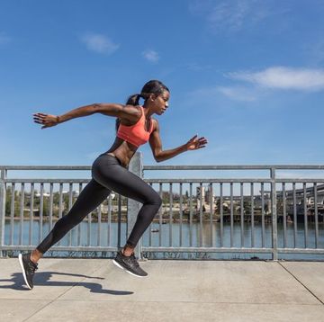Attractive ethnic female sprinter training in the city