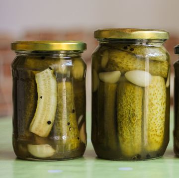close up of cucumbers in glass jar on table