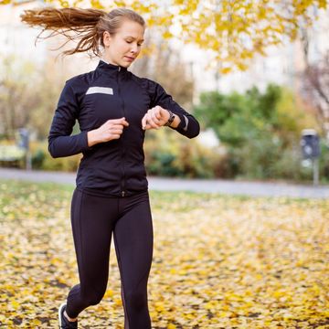 Female runner checking smartwatch while running