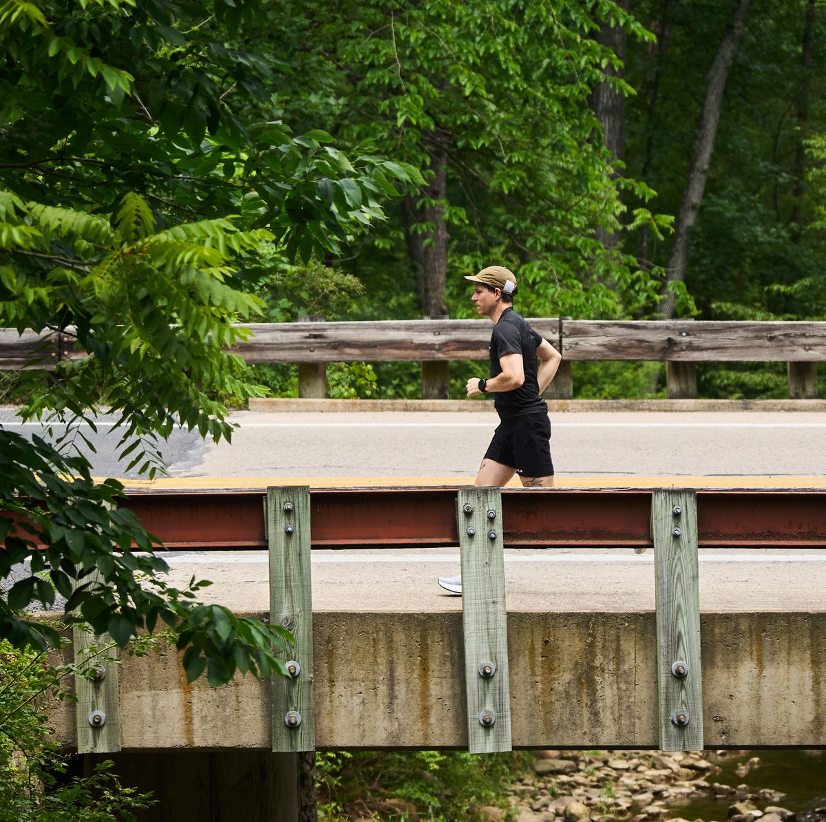 RWD a runner passes over a bridge with a creek below it