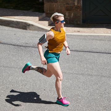 sue running down the street wearing earbuds