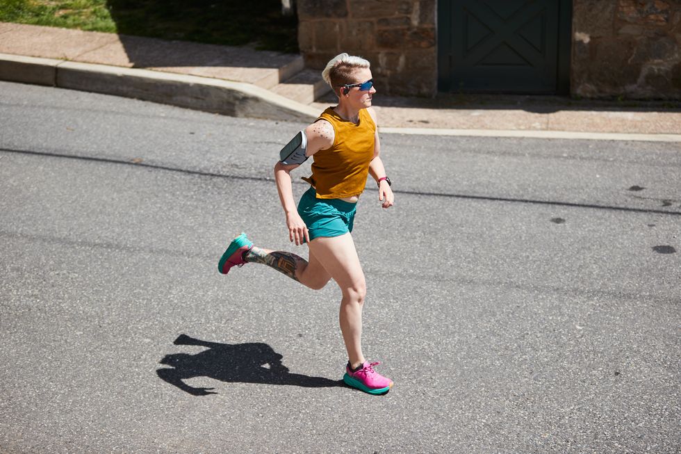 sue running down the street wearing earbuds