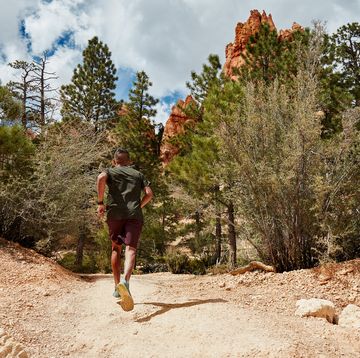 RWD man running down a dusty trail in bryce canyon