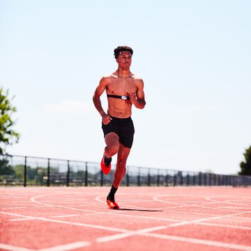 RWD man running on a track with a heart rate monitor