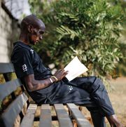 eliud kipchoge takes a quiet moment at home in elodoret, kenya, to read a book
