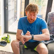 man checks watch after running workout