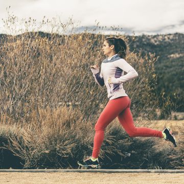 Side view of female athlete running by field side view of female athlete running by field