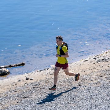 ultrarunner running along a river bank, guide to ultrarunning ultrarunner running along a river bank, guide to ultrarunning