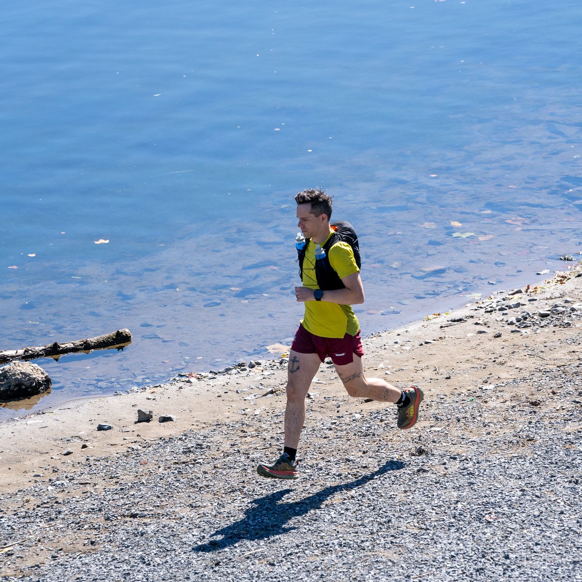 ultrarunner running along a river bank, guide to ultrarunning ultrarunner running along a river bank, guide to ultrarunning