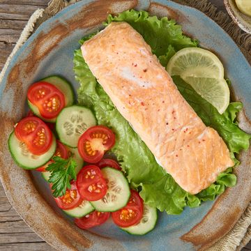 Steam salmon and vegetables, Paleo, keto, fodmap diet. Top view. Healthy diet concept, blue plate on old rustic wooden table