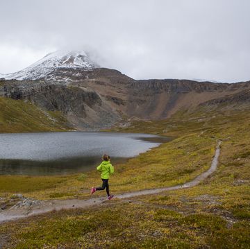 A woman on a trail run through a scenic area near Banff. a woman on a trail run through a scenic area near banff