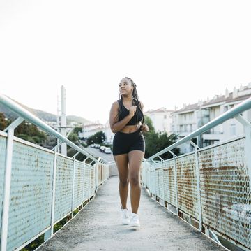 woman running on a urban bridge
