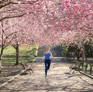 Woman running under blossoming trees, how to start running again woman running under blossoming trees, how to start running again