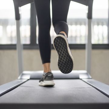 Women legs running on treadmill at the fitness gym. women legs running on treadmill at the fitness gym