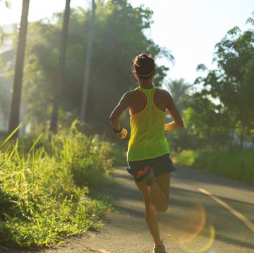 Young fitness woman running at morning tropical forest trail young fitness woman running at morning tropical forest trail