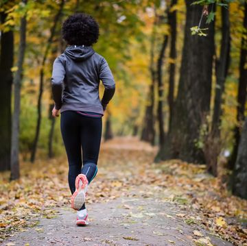 young woman jogging through the fall park