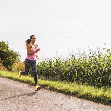 Young woman running on country lane Young woman running on country lane